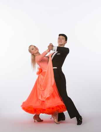 Two young ballroom dancers in studio taken against a high-key white backgroundの写真素材