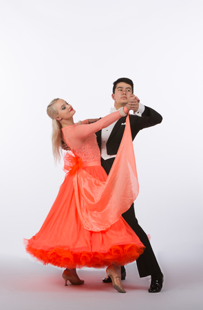 Two young ballroom dancers in studio taken against a high-key white backgroundの写真素材