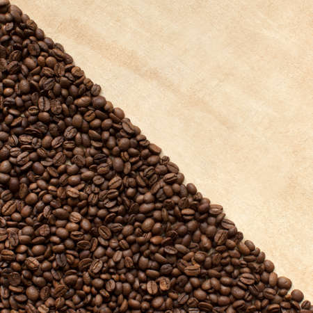 Coffee beans scatted on beige backgroundの写真素材