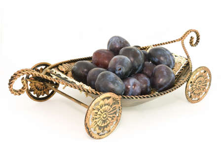 A lot of plums on the carriage isolated over white backgroundの写真素材