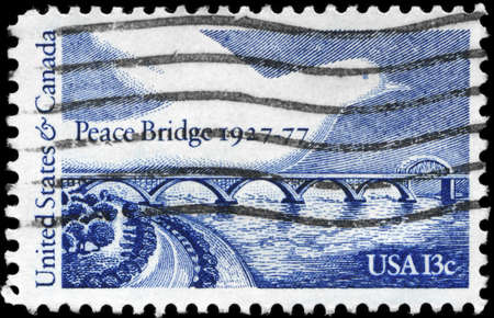 USA - CIRCA 1977: A Stamp printed in USA shows Peace Bridge & Dove, 50th anniversary issue, circa 1977の写真素材