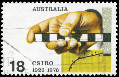 AUSTRALIA - CIRCA 1976: A Stamp printed in AUSTRALIA shows the Survey Rule, Graph, Punched Tape, Commonwealth Scientific and Industrial Research Organization, 50th anniversary, circa 1976の写真素材