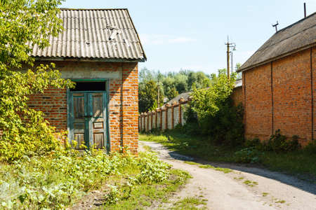 Landscape with countryside brick buildings and dirt roadの写真素材