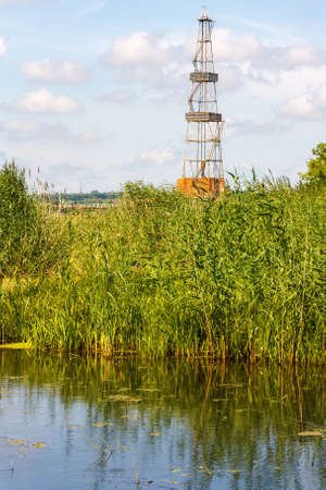 Landscape with the oil derrick and riverの写真素材