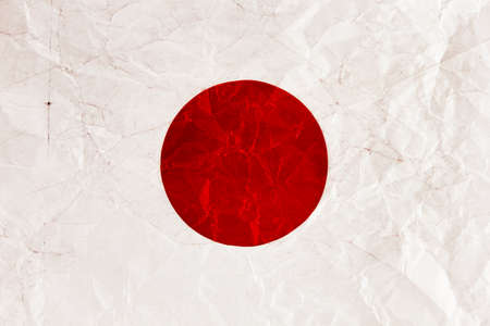 Japanese flag on a crumpled sheet of paperの写真素材