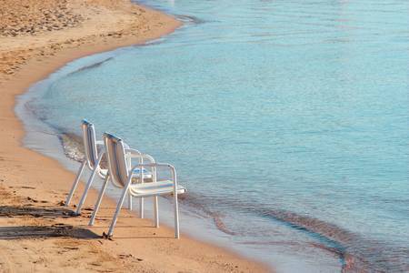 Two empty beach chairs on a lonely quite beach early in the morning. The location is at Hurghada, Egypt.の写真素材