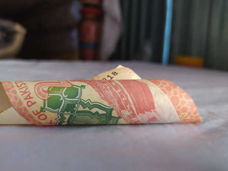 Brown man holdingpakistani currency notes on white background  A
