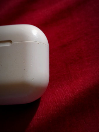 White computer mouse on a red background, shallow depth of field.