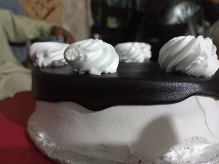 A white cake with a black and white frosting and white marshmallows