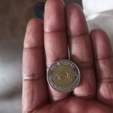 Close up of one euro coin in the hand of a young woman