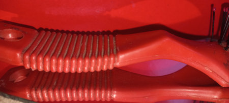 Close up shot of a red plastic hair clipper on a red backgroundの写真素材