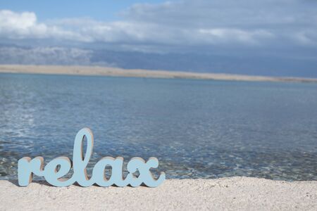 Relaxing time on the beach with sign relax