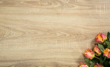 Fresh bouquet of rosses on the wooden background with some text spaceの写真素材