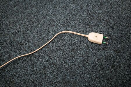 Unpluged lamp cable on the carpet floor. Old lamp cable