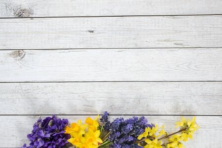 One of the first spring flowers on the wooden background, arranged in the bouquet