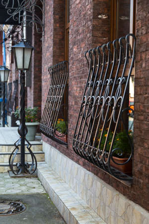 Red brick wall with metal windows and antique metal light poleの写真素材
