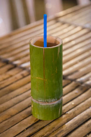 Bamboo wooden cup with traditional drink sold at night marketの写真素材