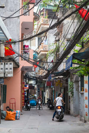HANOI, VIETNAM - CIRCA AUGUST 2015: People riding motorbikes on the narrow streets of Hanoi, Vietnamのeditorial素材