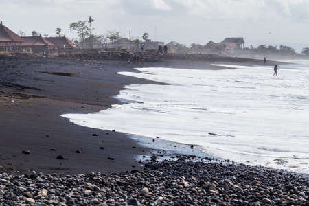Sanur, Bali/Indonesia - 09 24 2015: Public beach with black volcanic sand