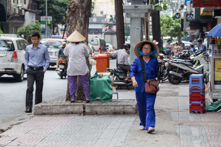 HO CHI MINH, VIETNAM - CIRCA AUGUST 2015: Pedestrian Vietnamese woman walks on the street of Ho Chi Minh City, Saigon, Vietnamのeditorial素材