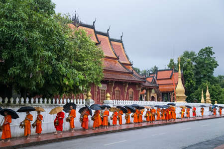 Luang Prabang, Laos - circa August 2015: Traditional Alms giving ceremony of distributing food to buddhist monks on the streets of Luang Prabang, Laosのeditorial素材