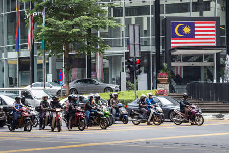 Kuala Lumpur, Malaysia - circa September 2015: Motorbike riders in street traffic on the road in Kuala Lumpur, Malaysiaのeditorial素材
