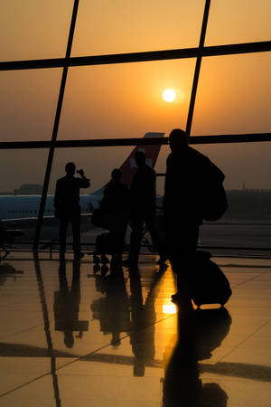 Beijing, China - circa September 2015: Silhouette of traveling people in the airport carrying bagsのeditorial素材