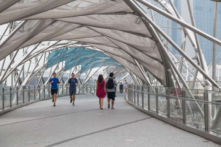 Singapore, Singapore - circa September 2015: People walking and running on Helix Bridge in Singaporeのeditorial素材
