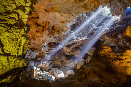 Sun rays come through ceiling hole in Dau Go cave in Halong Bayの写真素材