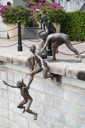 SINGAPORE, SINGAPORE - CIRCA SEPTEMBER 2015: Sculpture of boys jumping into the water, Singaporeのeditorial素材