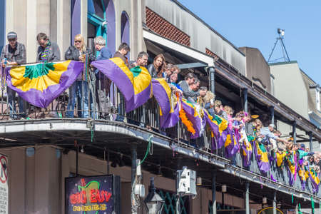New Orleans, LA/USA - circa February 2016: People throwing beads and watching celebration from balconies during Mardi Gras in New Orleans, Louisianaのeditorial素材