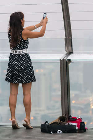 Cute young girl makes a selfie photography picture in the famous location outdoorの写真素材