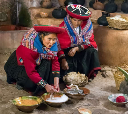 Ollantaytambo, Peru - circa June 2015: Women in traditional Peruvian clothes use natural dyes for Alpaca and Llama wool near Cusco, Peruのeditorial素材