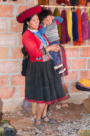 Ollantaytambo, Peru - circa June 2015: Women in traditional Peruvian clothes holds a boy near Cusco, Peruのeditorial素材