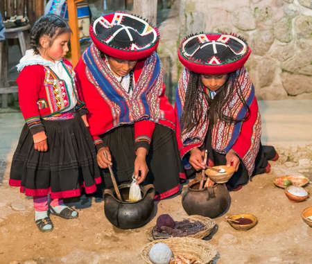 Ollantaytambo, Peru - circa June 2015: Women in traditional Peruvian clothes use natural dyes for Alpaca and Llama wool near Cusco, Peruのeditorial素材