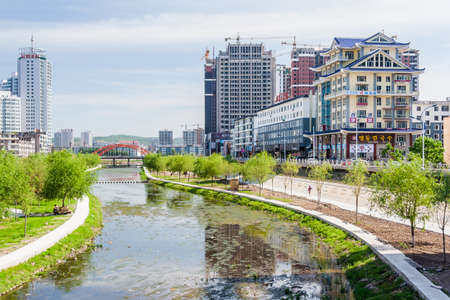 Jilin, China - circa July 2012: Songhua river and high rise residential buildings in Jilin, Chinaのeditorial素材
