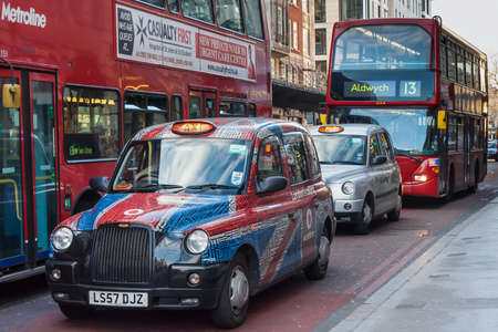 London, UK - circa March 2012: Double decker buses and cars with british flag on the streets of Londonのeditorial素材