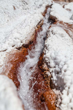 Water running between salt crystal deposits in evaporation ponds at Maras, Peruの写真素材