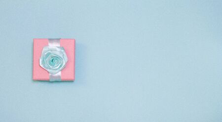 Small gift box with rose on bright blue backgroundの写真素材