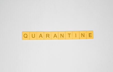 Word quarantine made of yellow wooden letters on gray backgroundの写真素材