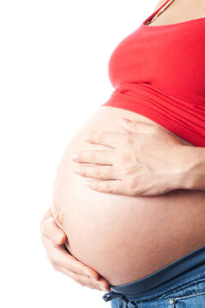 Pregnant woman holding her belly with hands over white backgroundの写真素材