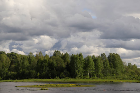 Landscape with low rain clouds above the forest near the riverの写真素材