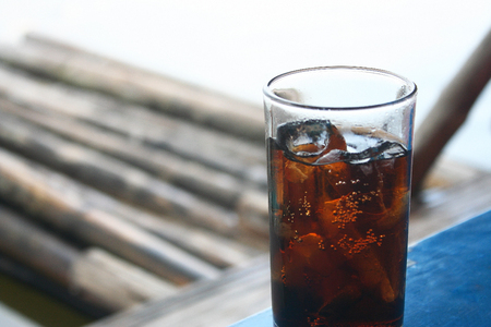 Glass of soft drink on bamboo raft in the lakeの写真素材