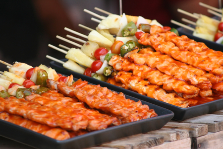 Stacked barbecues with sauce in black tray on wooden tableの写真素材