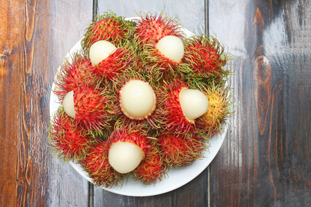 Fresh red rambutan in white plateの写真素材