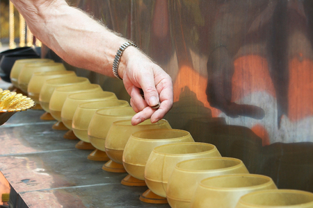 Man putting coins in monk's alms bowl.の写真素材