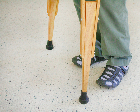 Man using wood crutches on terrazzo floor backgroundの写真素材