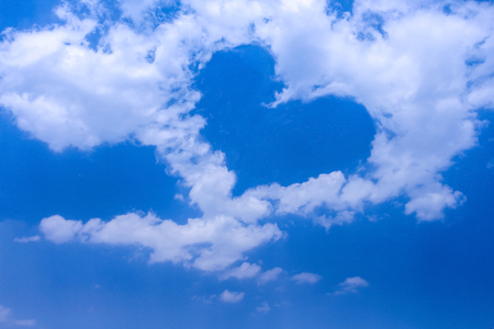White cloud group patterns with  heart shaped on bright blue skyの写真素材