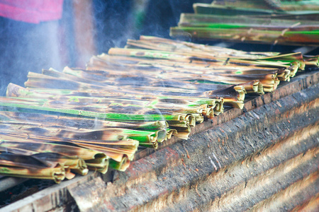 Sticky rice with coconut in palm leaf  roasted over a charcoal fire , thai dessertの写真素材