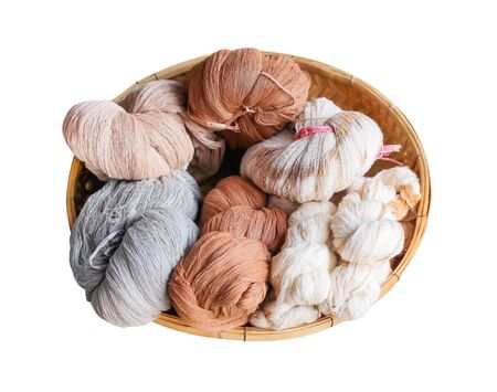 Multicolored raw cotton thread in wood tray isolated on white background